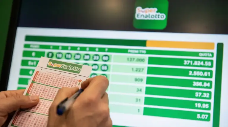Persona che compila una schedina del Superenalotto davanti a uno schermo con risultati e quote della vincita